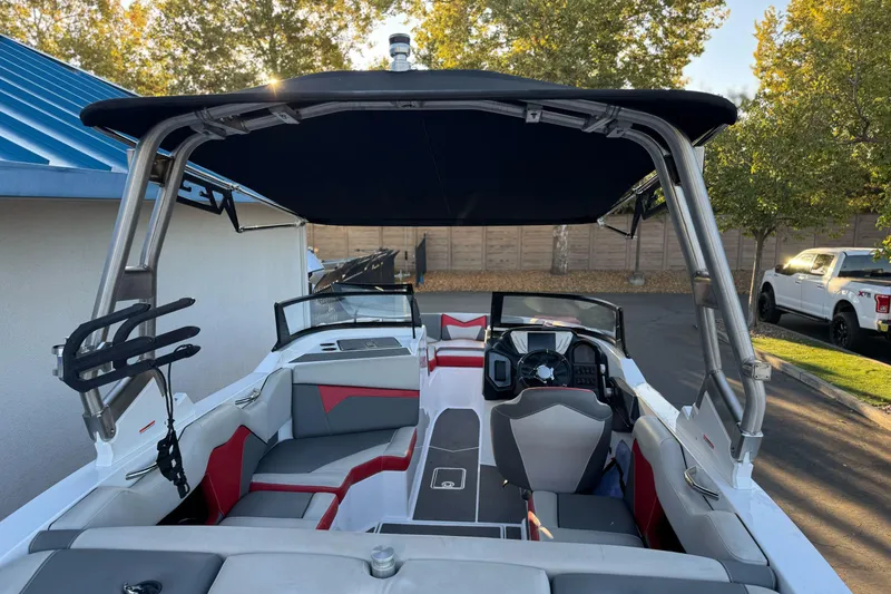 Slide: The Image of 2023 Supreme ZS212 boat interior with seating, steering wheel, and canopy in a driveway setting. - 33
