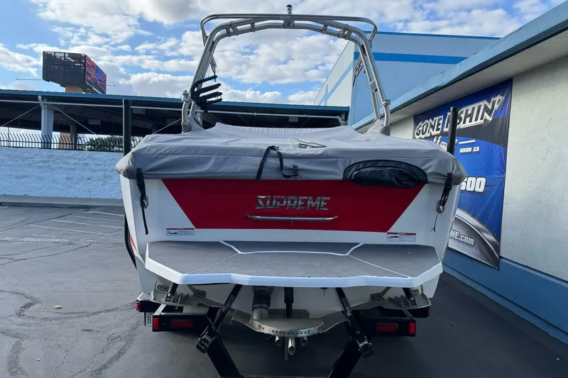 Slide: The Image of 2023 Supreme ZS212 boat in red and white on a trailer, parked outside a building. - 4