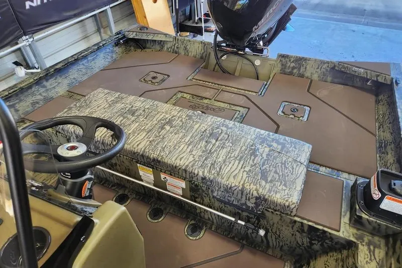 Slide: The Image of 2026 Tracker Grizzly 2072 CC boat interior with camo design and steering console. - 10