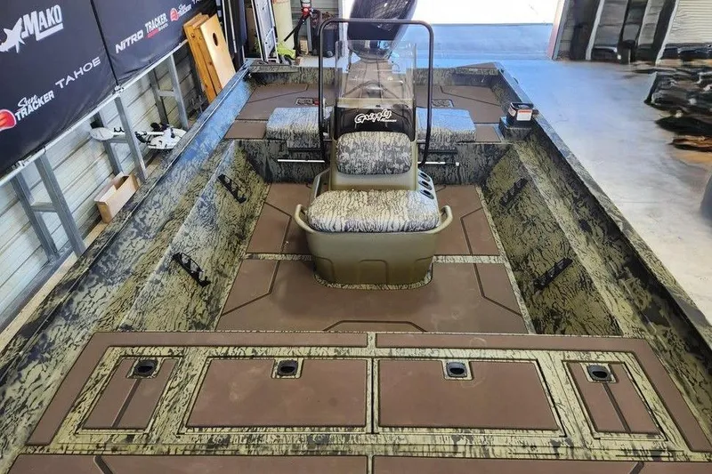 Slide: The Image of 2026 Tracker Grizzly 2072 CC boat interior with camo design and central console. - 11