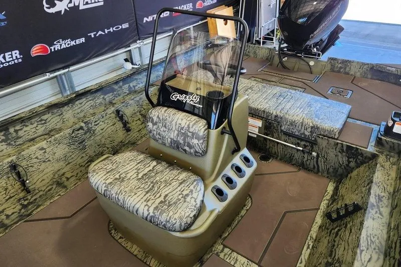 Slide: The Image of 2026 Tracker Grizzly 2072 CC boat interior with camo seats and console. - 13