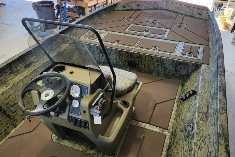 Slide: The Image of 2026 Tracker Grizzly 2072 CC boat interior with steering console and camouflage design. - 6