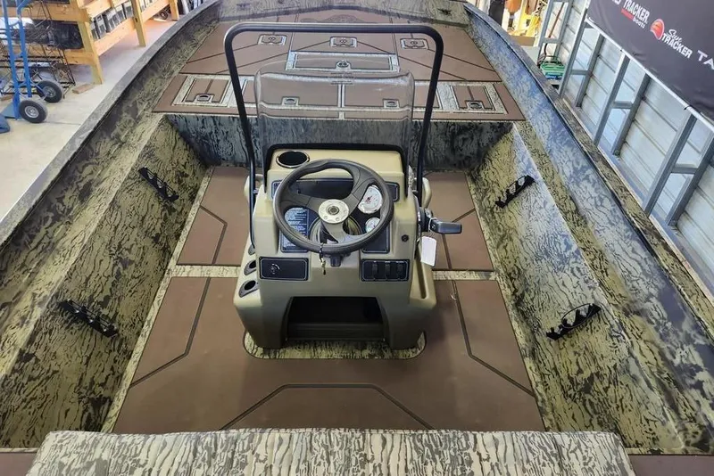Slide: The Image of 2026 Tracker Grizzly 2072 CC boat interior with camouflage design and central steering console. - 8