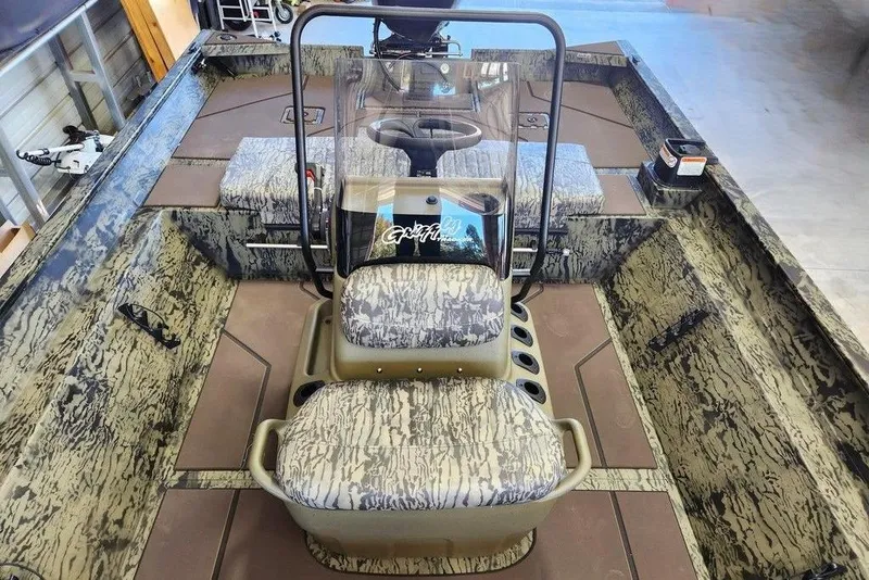 Slide: The Image of 2026 Tracker Grizzly 2072 CC boat interior with camouflage seating and console. - 9