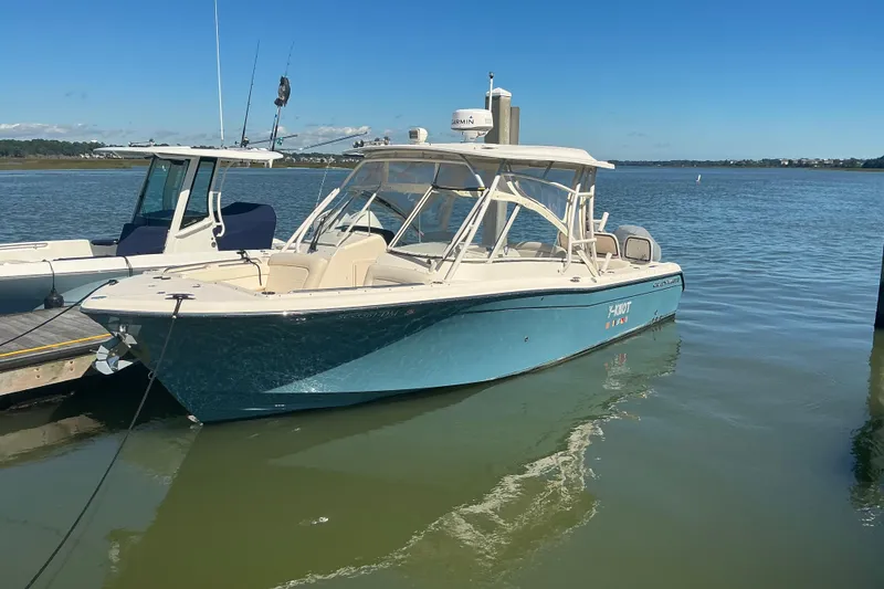 The Image of 2020 Grady-White Freedom 285 boat docked on calm water under clear blue sky. - 1