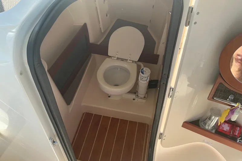 Slide: The Image of 2020 Grady-White Freedom 285 boat interior bathroom with toilet and wooden flooring. - 16