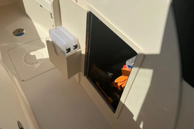 Slide: The Image of 2020 Grady-White Freedom 285 boat storage compartment with visible gear and accessories. - 20