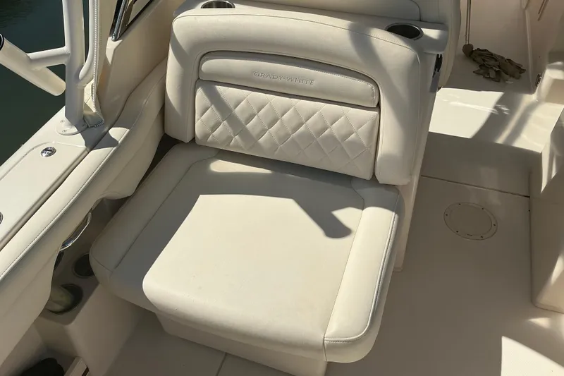 Slide: The Image of 2020 Grady-White Freedom 285 boat seat with white upholstery and cup holders. - 24
