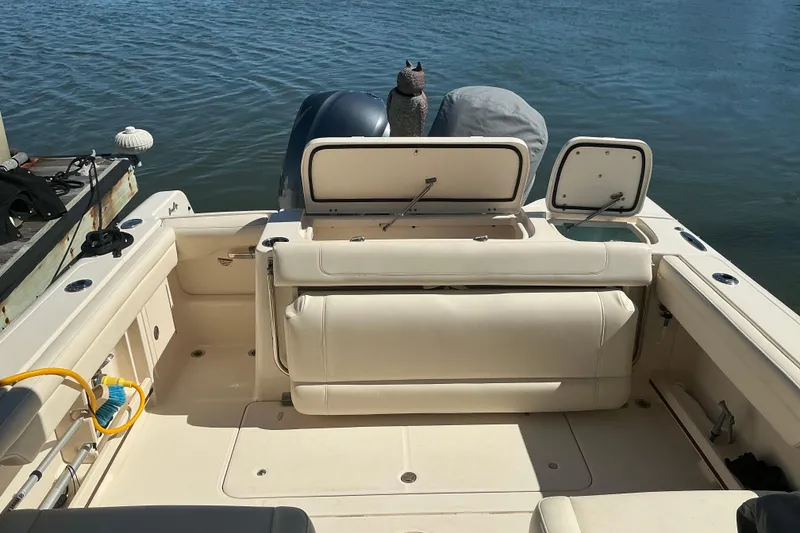 Slide: The Image of 2020 Grady-White Freedom 285 boat interior with open storage compartments, docked by the water. - 26