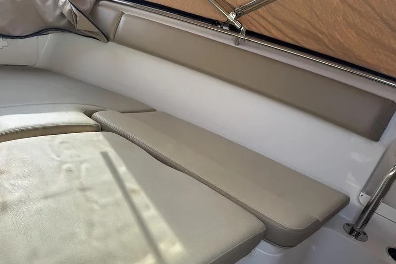 Slide: The Image of 2021 Sailfish 290 CC boat interior with beige cushioned seating. - 10