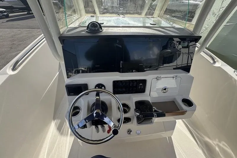 Slide: The Image of 2021 Sailfish 290 CC boat helm with steering wheel and control panel. - 11