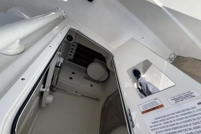 Slide: The Image of Interior view of 2021 Sailfish 290 CC boat cabin with toilet and mirror. - 14