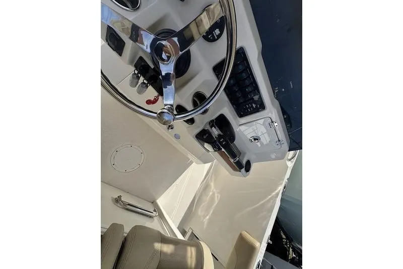 Slide: The Image of 2021 Sailfish 290 CC boat dashboard with steering wheel and controls. - 16