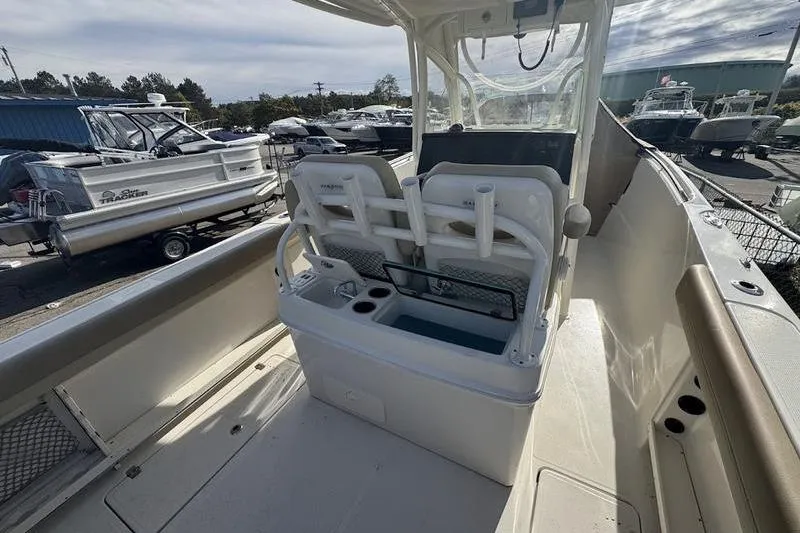Slide: The Image of 2021 Sailfish 290 CC boat interior with seating and console, docked among other boats. - 18