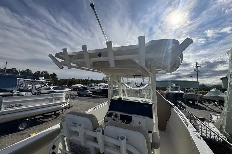 Slide: The Image of 2021 Sailfish 290 CC boat with center console, docked under a partly cloudy sky. - 21