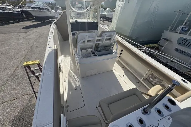 Slide: The Image of 2021 Sailfish 290 CC boat interior with seating and console, docked among other boats. - 22
