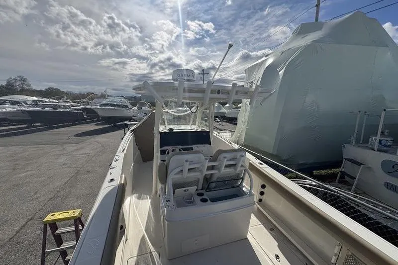 Slide: The Image of 2021 Sailfish 290 CC boat with dual seats, parked outdoors under cloudy sky. - 24