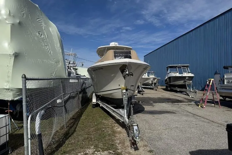 Slide: The Image of 2021 Sailfish 290 CC boat on trailer in storage yard, blue sky background. - 4