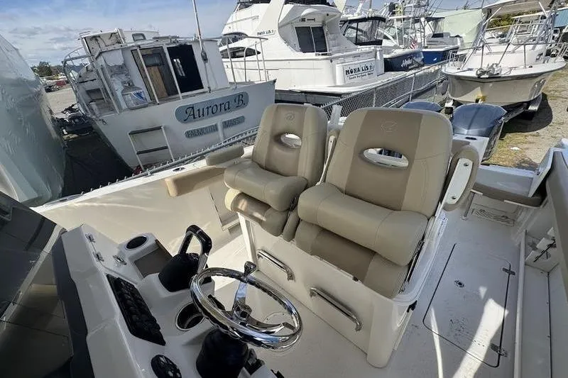 Slide: The Image of 2021 Sailfish 290 CC boat interior with dual captain seats and steering wheel. - 8
