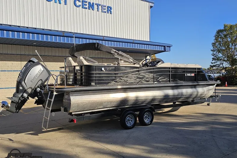 Slide: The Image of 2015 Bennington 2550 QBR pontoon boat on trailer outside a sport center. - 12