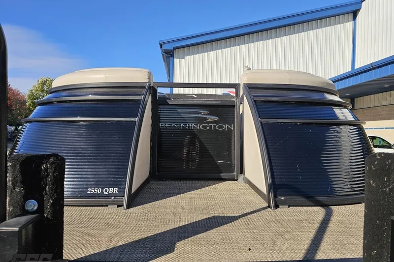 Slide: The Image of 2015 Bennington 2550 QBR pontoon boat displayed outdoors near a warehouse. - 18