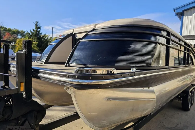 Slide: The Image of 2015 Bennington 2550 QBR pontoon boat on trailer, outdoor setting, sunny day. - 21