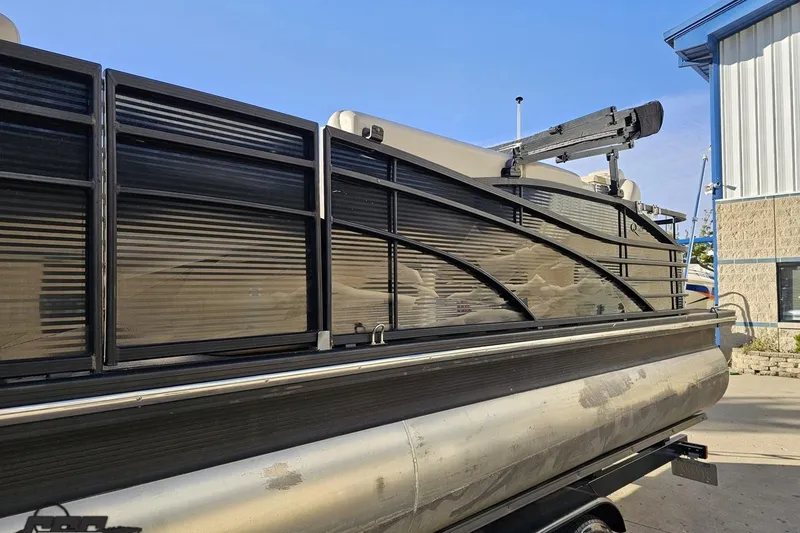 Slide: The Image of 2015 Bennington 2550 QBR pontoon boat parked near a building. - 23