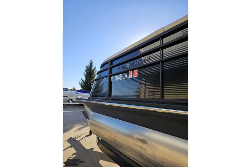 Slide: The Image of 2015 Bennington 2550 QBR pontoon boat, close-up view with clear sky background. - 25
