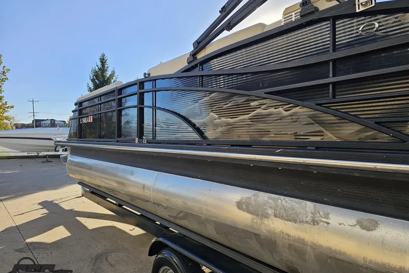 Slide: The Image of 2015 Bennington 2550 QBR pontoon boat parked outdoors on a sunny day. - 29