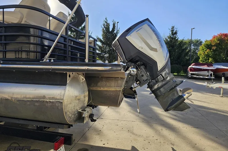 Slide: The Image of 2015 Bennington 2550 QBR pontoon boat with outboard motor, parked outdoors. - 31