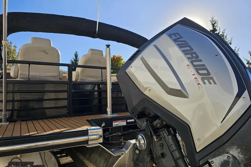 Slide: The Image of 2015 Bennington 2550 QBR pontoon boat with Evinrude E-TEC engine, featuring comfortable seating. - 32
