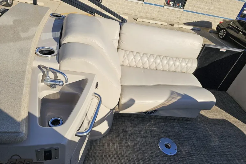 Slide: The Image of 2015 Bennington 2550 QBR boat interior with beige seating and built-in sink. - 47