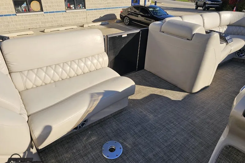 Slide: The Image of 2015 Bennington 2550 QBR boat interior with beige seating and carpeted flooring. - 48