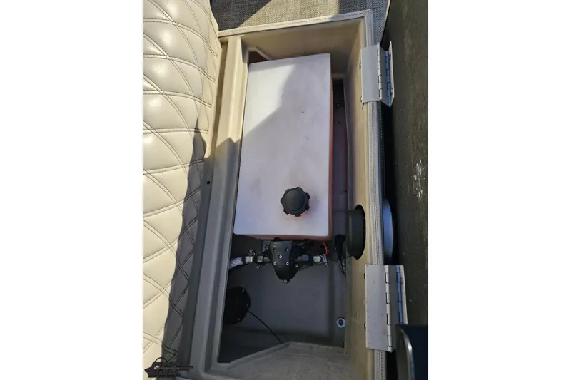 Slide: The Image of 2015 Bennington 2550 QBR storage compartment with beige upholstery and mechanical components. - 50