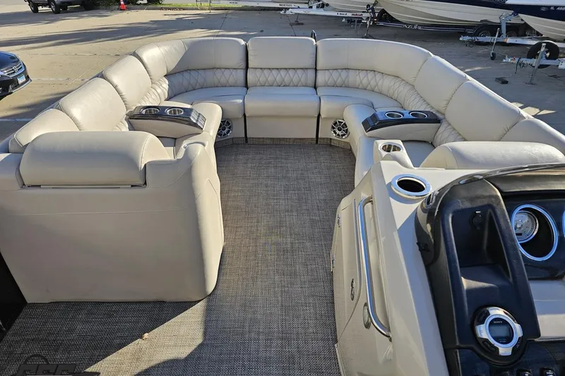 Slide: The Image of Luxurious seating on a 2015 Bennington 2550 QBR pontoon boat, featuring plush upholstery and cup holders. - 51