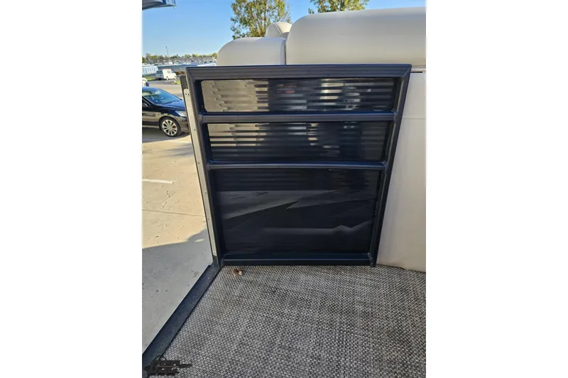 Slide: The Image of 2015 Bennington 2550 QBR boat gate with sleek black design, docked outdoors. - 54