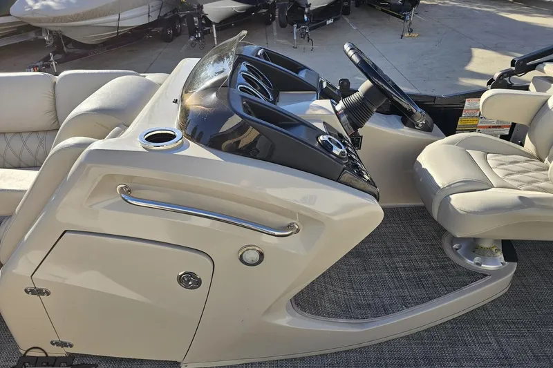 Slide: The Image of 2015 Bennington 2550 QBR boat interior with steering console and cushioned seating. - 65