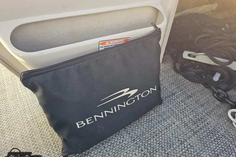 Slide: The Image of Bennington 2550 QBR 2015 boat with branded storage bag and safety warning. - 67