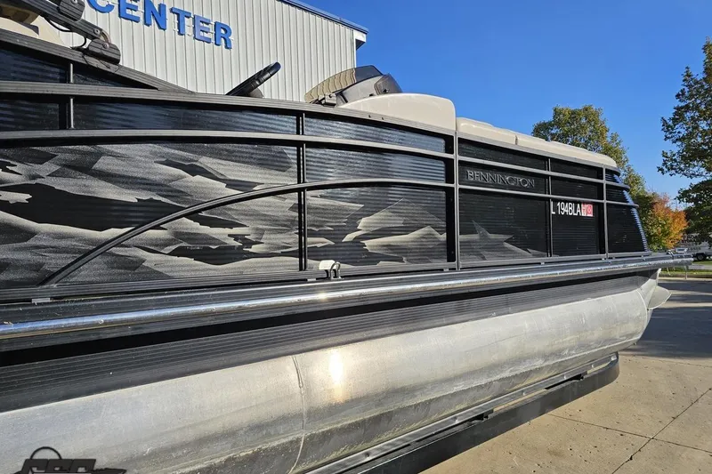Slide: The Image of 2015 Bennington 2550 QBR pontoon boat with sleek black design, parked outdoors. - 7