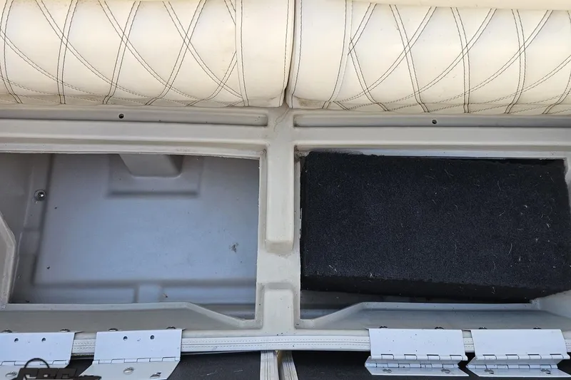 Slide: The Image of Interior storage compartments of a 2015 Bennington 2550 QBR boat with cushioned seating. - 78