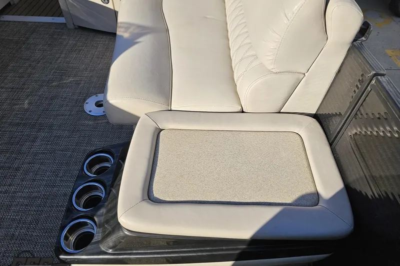 Slide: The Image of 2015 Bennington 2550 QBR boat interior with beige seating and cup holders. - 84