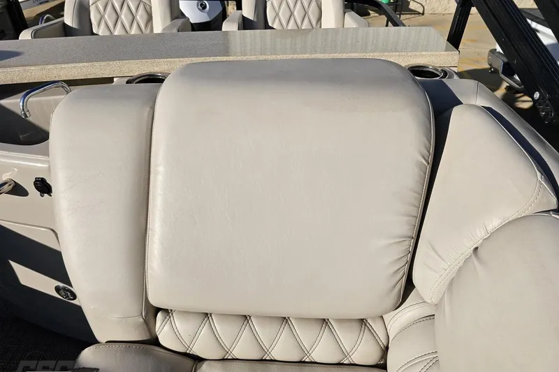 Slide: The Image of 2015 Bennington 2550 QBR boat interior with beige leather seating and table. - 90