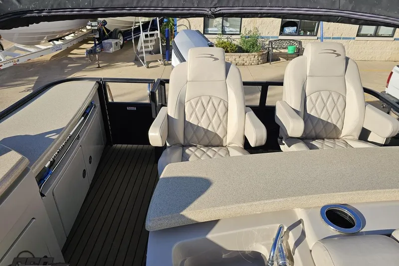 Slide: The Image of Interior of a 2015 Bennington 2550 QBR boat with plush seating and sleek design. - 93