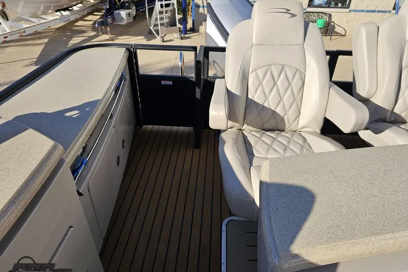 Slide: The Image of 2015 Bennington 2550 QBR boat interior with luxury seating and sleek design. - 97