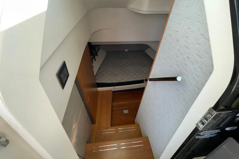 Slide: The Image of 2023 Tiara Yachts 34 LS cabin interior with wooden steps and cozy sleeping area. - 25