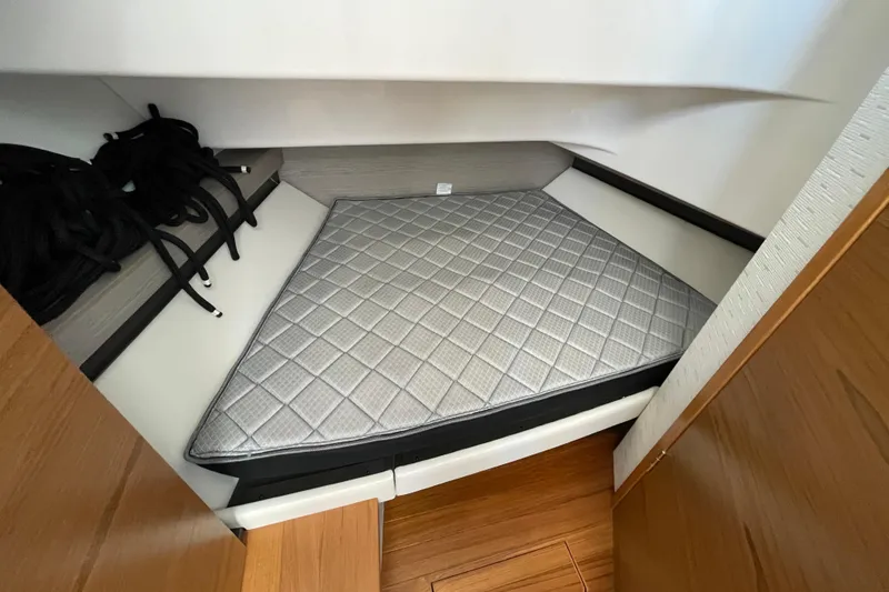 Slide: The Image of 2023 Tiara Yachts 34 LS cabin interior with mattress and storage space. - 27