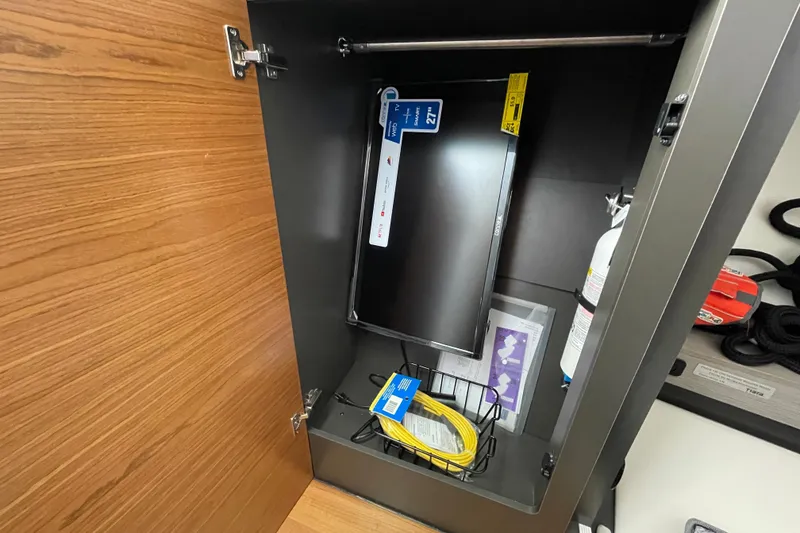 Slide: The Image of 2023 Tiara Yachts 34 LS interior cabinet with monitor and fire extinguisher. - 29