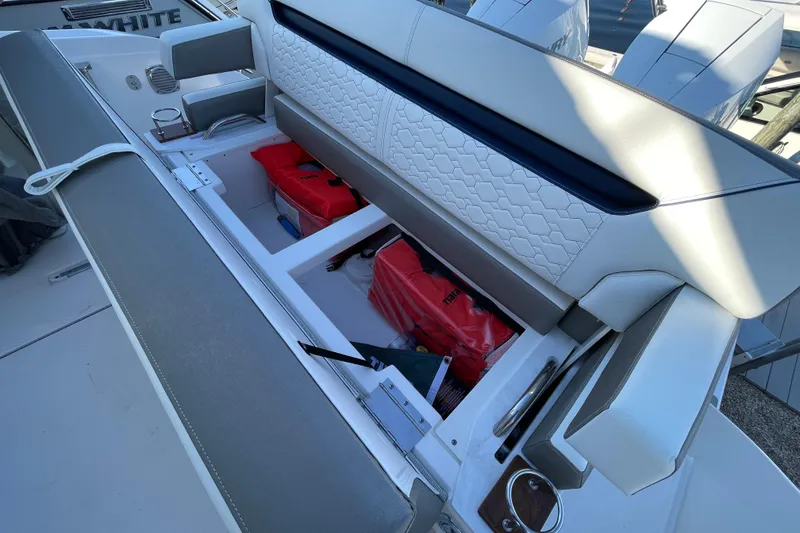 Slide: The Image of 2023 Tiara Yachts 34 LS boat seat storage with red life jackets. - 43