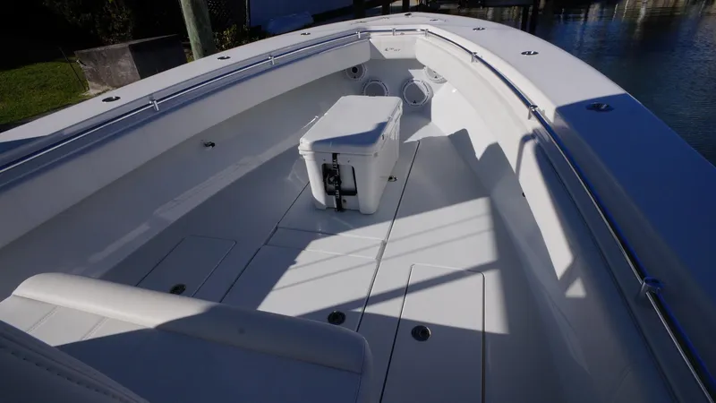 Slide: The Image of 2023 Contender 32 ST boat interior with seating and storage, docked by the water. - 10