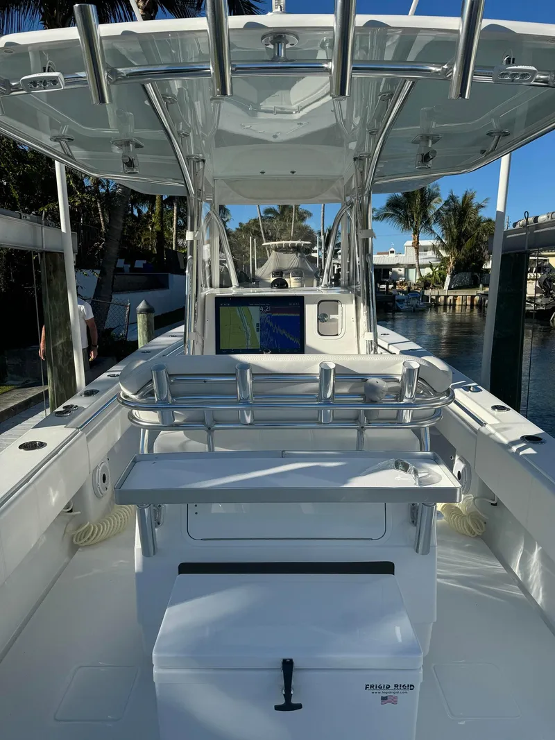 Slide: The Image of 2023 Contender 32 ST boat interior with navigation system and seating, docked by the water. - 14